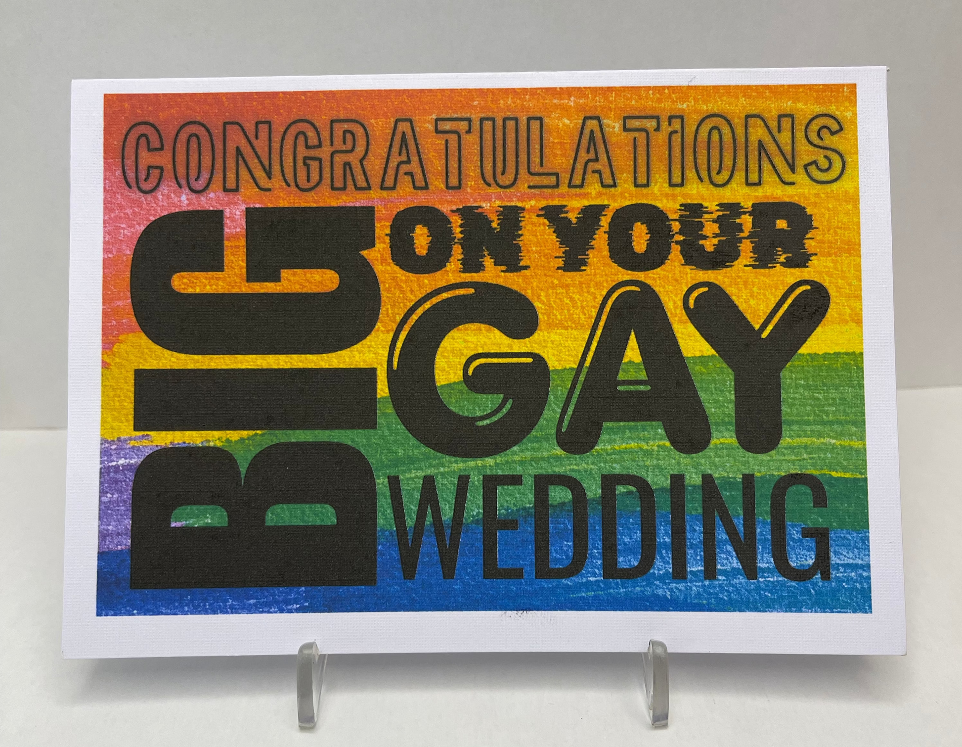 Card with rainbow design and text 'Congratulations on your big gay wedding' on a white background