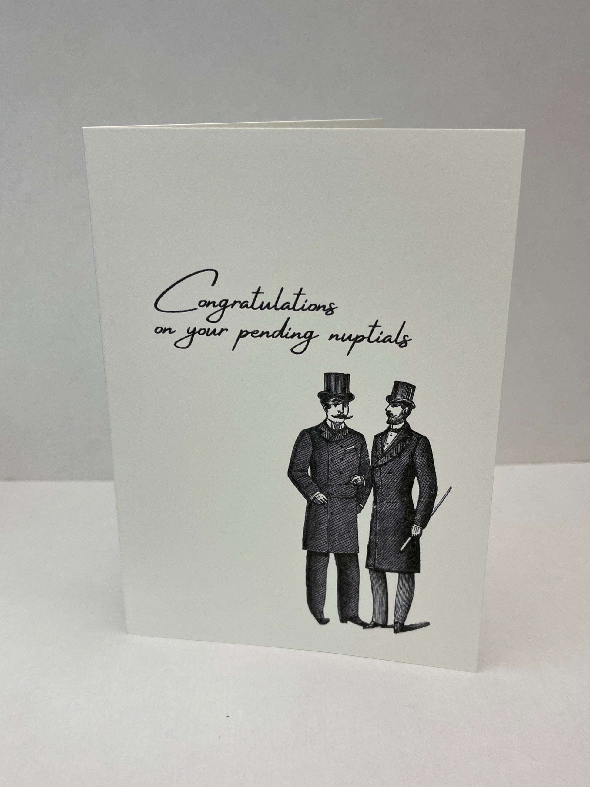 Greeting card with two men in suits and top hats and text 'Congratulations on your pending nuptials' on a gray background.