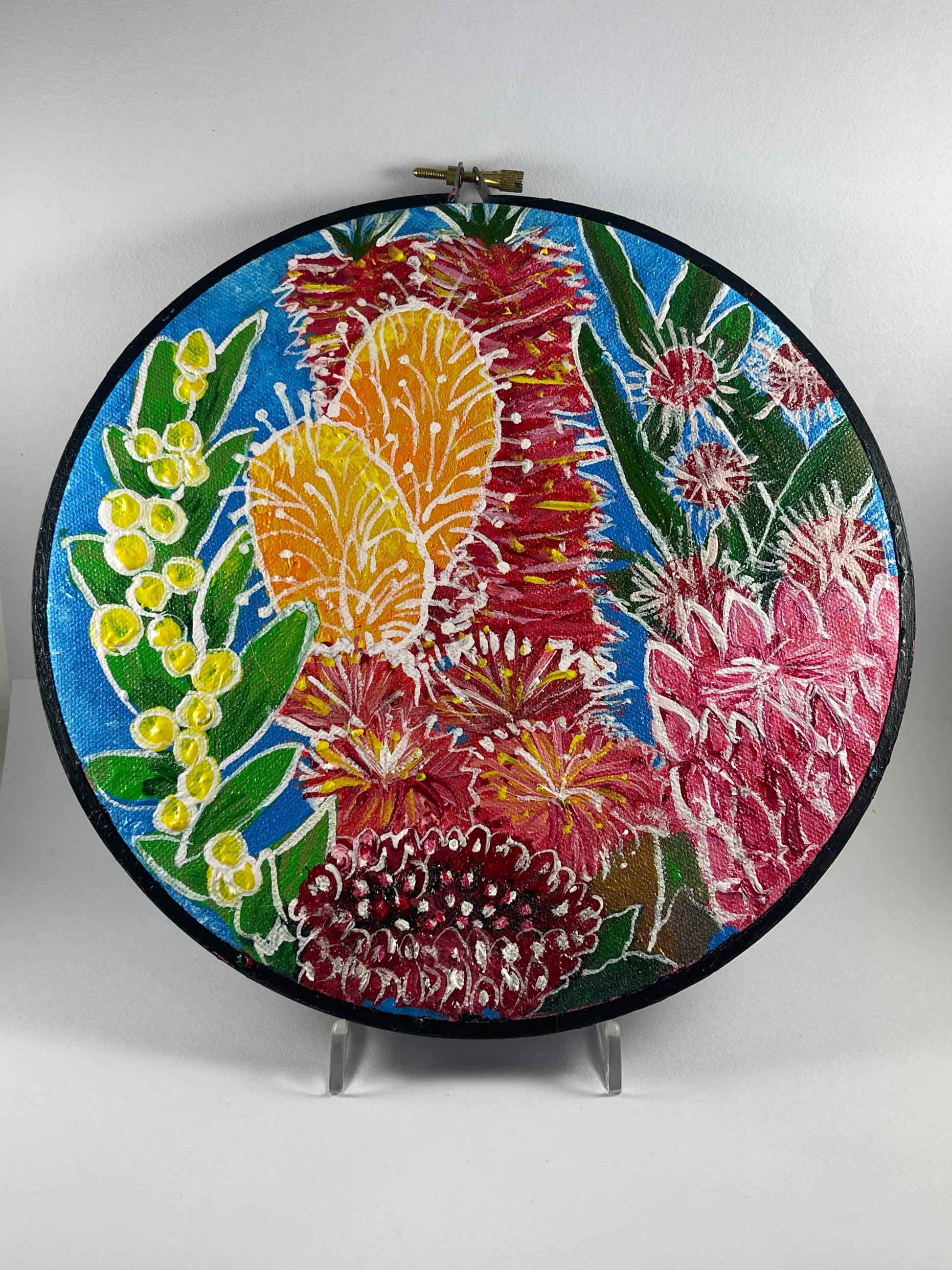Embroidery hoop with colorful floral design on a white background