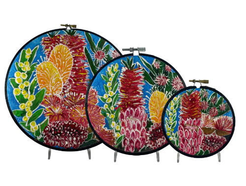 Set of three floral embroidery hoops with colorful floral patterns on a white background